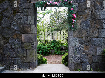 Stone Gateway to a Lush Garden of Camelia Hill in Jeju Island Stock Photo