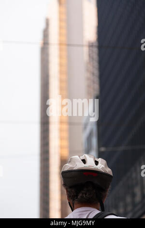 A cyclist and his helmet with tall buildings in the background in Downtown Toronto, Ontario, Canada. Stock Photo
