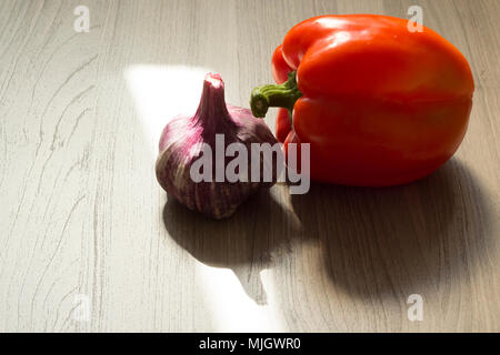 Bulgarian pepper and garlic head lie on a wooden table Stock Photo