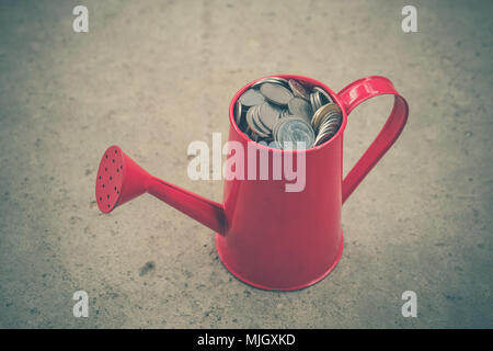 coin in red Watering-Can with filter effect retro vintage style Stock Photo