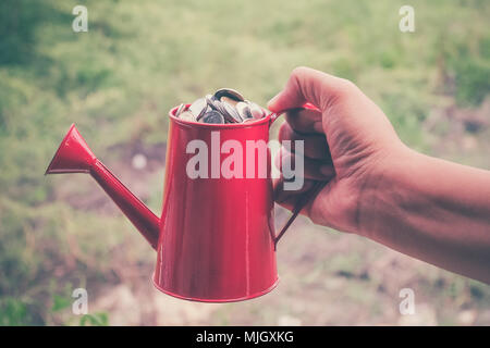 coin in red Watering-Can with filter effect retro vintage style Stock Photo