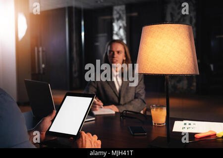 Two coworkers meet in night loft office. Manager conducts an interview. Dialogue of businessmen about a new startup Stock Photo