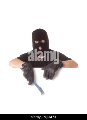 A man masked by wearing balaclava holding a crowbar in his hand on a white background. Stock Photo