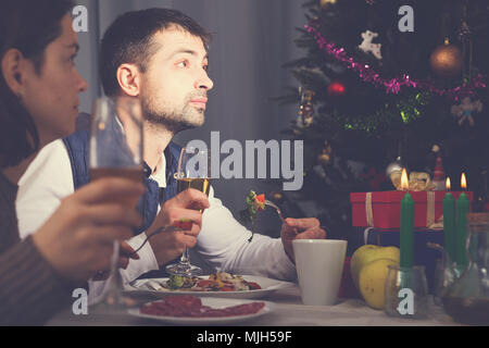 Family couple having christmas dinner with champagne and watching tv Stock Photo