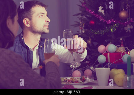 Family couple having christmas dinner with champagne and watching tv Stock Photo