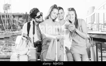 Group of friends travellers smiling and making selfie with mobile phone Stock Photo