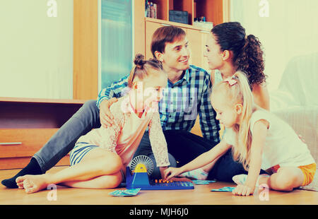 Cheerful parents and daughters with toy lotto in a home Stock Photo