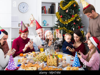 Large happy russian  family making numerous photos during Christmas dinner Stock Photo