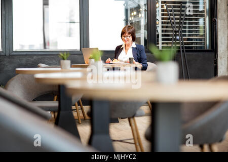 Senior business woman eating in the cafe Stock Photo