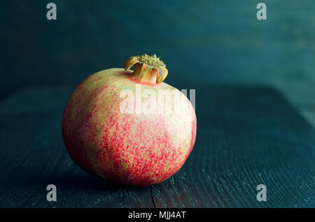 Pomegranate over dark wooden background Stock Photo