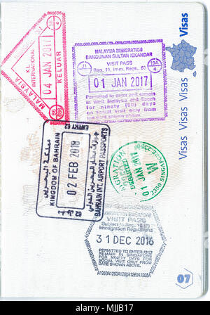 Stamps of Malaysia, Bahrain and Singapore in a French passport. Personal data removed Stock Photo