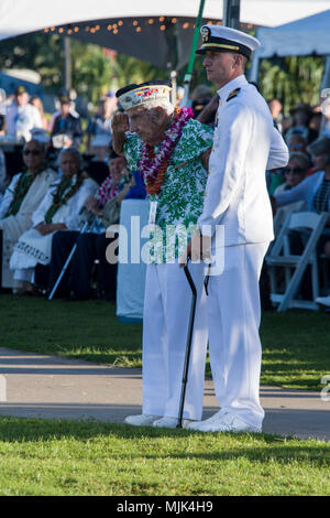 171207-N-YW024-0239 PEARL HARBOR (Dec. 7, 2017) Lt. Cmdr. Michael Genta assists Chief Storekeeper (ret.) Al Rodrigues as he leads the ceremony in rendering honors to the USS Arizona crew still entombed inside the ship during the 76th Anniversary of the attacks on Pearl Harbor and Oahu at Joint Base Pearl Harbor-Hickam. The 76th commemoration, co-hosted by the U.S. Military, the National Park Service and the State of Hawaii, provided veterans, family members, service members and the community a chance to honor the sacrifices made by those who were present Dec. 7, 1941, as well as throughout the Stock Photo