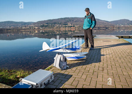 Radio Controlled (RC) seaplane. Float plane model on the shore of a lake ready to fly. Lake Comabbio, Corgeno, Italy Stock Photo