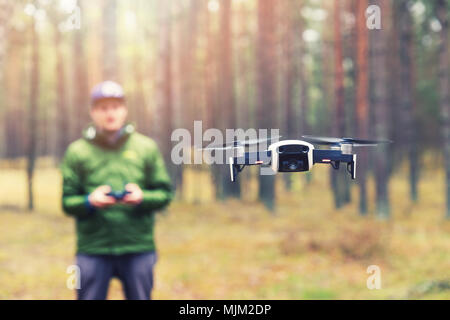 man flying drone in the woods Stock Photo