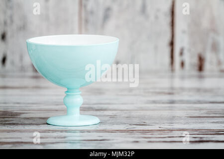 Turquoise plastic ice cream bowl on white wooden background Stock Photo