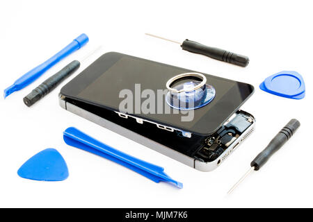 A damaged smartphone with the tools needed for replacement  or repair on an isolated white background Stock Photo
