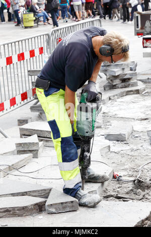 Copenhagen, Denmark - A construction worker uses an electric jackhammer at Amagaertorv in downdown Copenhagen. Stock Photo