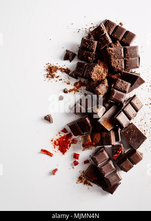 Chunks of dark chocolate with spices on white background. Stock Photo