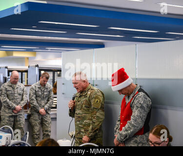 Col. Philip G. Houser, Nebraska National Guard Chaplain, leads a prayer before the holiday at the Nebraska National Guard DFAC in Lincoln, Nebraska, Dec. 6, 2017. Members of the 155th Air Refueling Wing gathered for a pot-luck lunch to celebrate the holiday season. Stock Photo