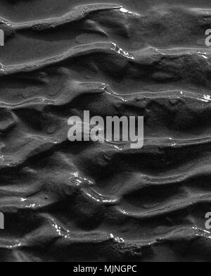 Wave patterns on sand by the beach in black and white close-up in portrait Stock Photo