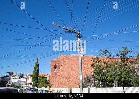 Telegraph pole with many wires attached in a Melbourne suburb. Horizontal with a clear blue sky background. Stock Photo