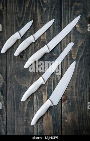 White ceramic chopping knife set on blue wooden background Stock Photo
