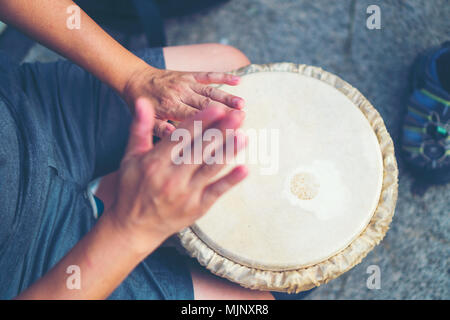 People hands playing music at djembe drums, vintage filter image Stock Photo