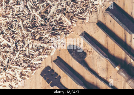 Carpenter tools on wooden table with sawdust. Carpenter workplace top view Stock Photo