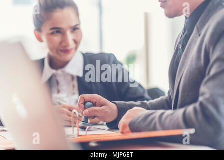 Two analysts discussing online data in front of laptop Stock Photo