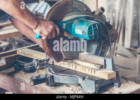Background image of woodworking workshop: carpenters work table with different tools and wood cutting stand, vintage filter image Stock Photo