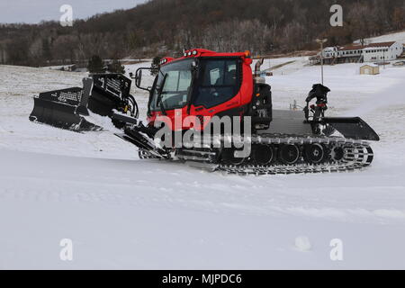 Whitetail Ridge Ski Area at Fort McCoy, Wisconsin, operates as a winter sports facility open to the public. On Dec. 12, 2017, personnel used grooming machinery and snowmaking systems to ready the slopes for seasonal activities. The archival image preserves operational details of snow distribution equipment and maintained ski runs. Stock Photo