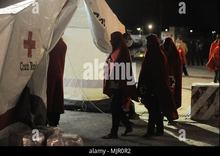 Malaga, Spain. 6th May, 2018. Migrants who were rescued from a dinghy in the Mediterranean Sea, walk past inside a tent of Spanish Red Cross after their arrival at Port of Malaga. Members of the Spanish Maritime Safety rescued in this early morning a total of 110 migrants from two boats near the Malaga coast. Credit: Jesus Merida/SOPA Images/ZUMA Wire/Alamy Live News Stock Photo