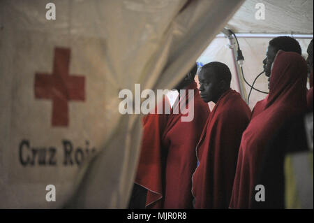 Malaga, Spain. 6th May, 2018. Migrants who were rescued from a dinghy in the Mediterranean Sea, wait inside a tent of Spanish Red Cross to be assisted after their arrival at Port of Malaga. Members of the Spanish Maritime Safety rescued in this early morning a total of 110 migrants from two boats near the Malaga coast. Credit: Jesus Merida/SOPA Images/ZUMA Wire/Alamy Live News Stock Photo