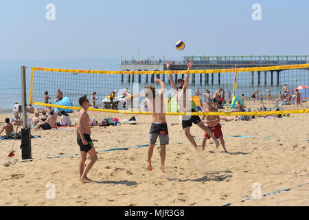 Boscombe, Bournemouth, Dorset, UK, 6th May 2018, Weather: Morning sunshine on the south coast on what could be the hottest Mayday bank holiday weekend on record. Young men playing beach volleyball in perfect conditions.