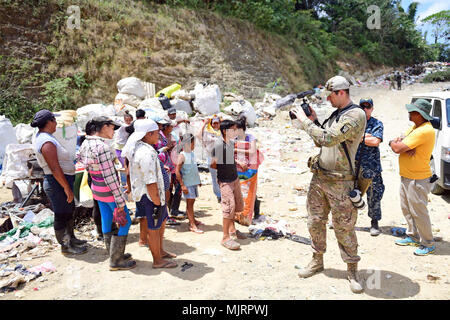 PUERTO CORTES, Honduras (March 21, 2018) Staff Sgt. Clark Luksan records Honduran locals at the city's landfill during Continuing Promise 2018. U.S. Naval Forces Southern Command/U.S. 4th Fleet has deployed a force to execute Continuing Promise to conduct civil-military operations including humanitarian assistance, training engagements, and medical, dental, and veterinary support in an effort to show U.S. support and commitment to Central and South America. Armed Forces and civilians displaying courage bravery dedication commitment and sacrifice Stock Photo