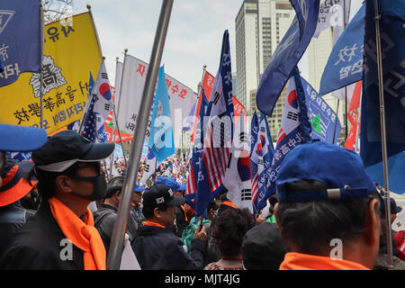 Many flags and banners held above the crowd at a political rally in Seoul, South Korea, on March 31, 2018; photo taken from inside the crowd. Stock Photo