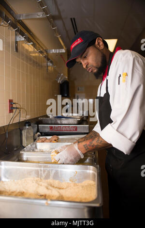 A civilian food services employee prepares food during The Officer 