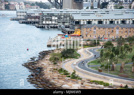 Sydney,NSW,Australia-December 7,2016: People walking on harbour side walking path with luxury waterfront apartments in Sydney, Australia Stock Photo