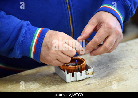 Close up view of man working at assembling line with electric components Stock Photo