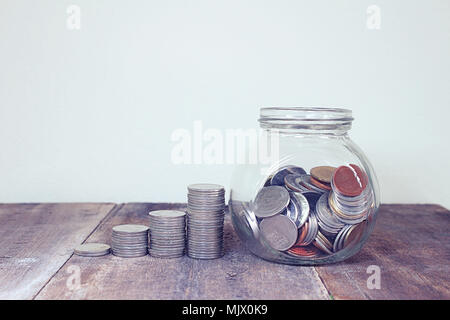 Stack of money and coin on cup glass. Stock Photo