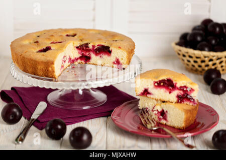 Homemade plum cake on a glass stand. Selective focus. Stock Photo