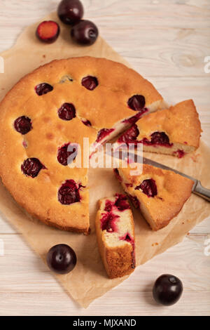Home plum pie on baking paper. Selective focus. Stock Photo
