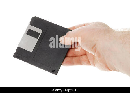 One human hand holding a black 3½ inch manetic diskette isolated on white. Stock Photo