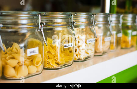 Various raw pasta selection in labeled jars Stock Photo