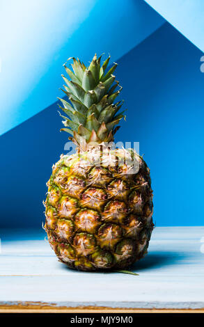 Whole pineapple fruit against blue background Stock Photo