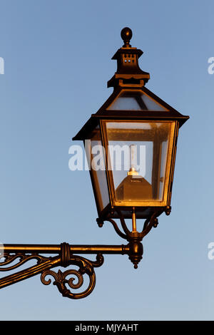 Close-up of an old style street lamp with a modern light bulb inside. Stock Photo