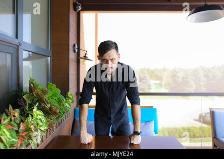 Young male manager standing at office and wearing black shirt. Stock Photo