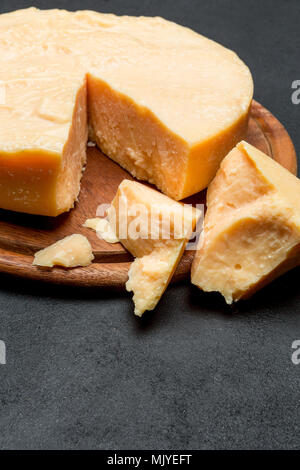 Whole round Head and pieces of parmesan or parmigiano Stock Photo