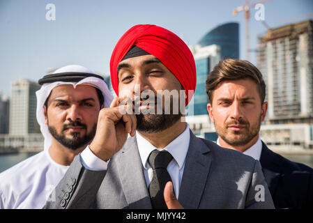 Multiethnic business team meeting outdoors - Three businessmen talking about business on a formal meeting Stock Photo