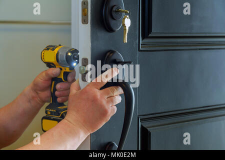 house exterior door with the inside internal parts of the lock visible of a professional locksmith installing or repairing a new deadbolt lock Stock Photo